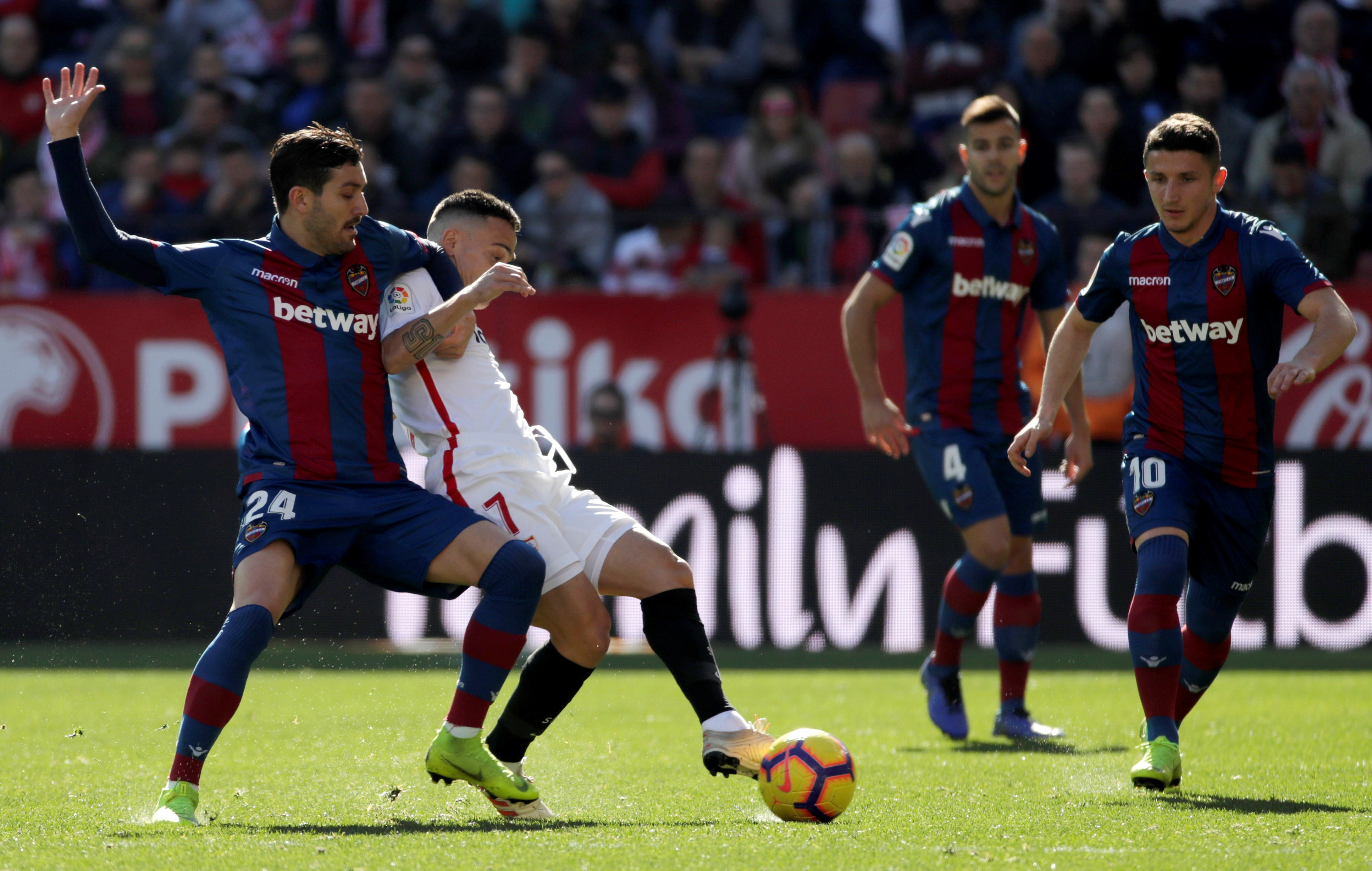 epa07321336 Sevilla's FC midfielder Roque Mesa (2L) vies for the ball with Levante's FC midfielder Jose Gomez Campana (L) during the Primera Division Liga match between Sevilla FC and Levante UD at Sanchez Pijun stadium in Seville, Spain, 26 January 2019. EPA-EFE/Julio Munoz
